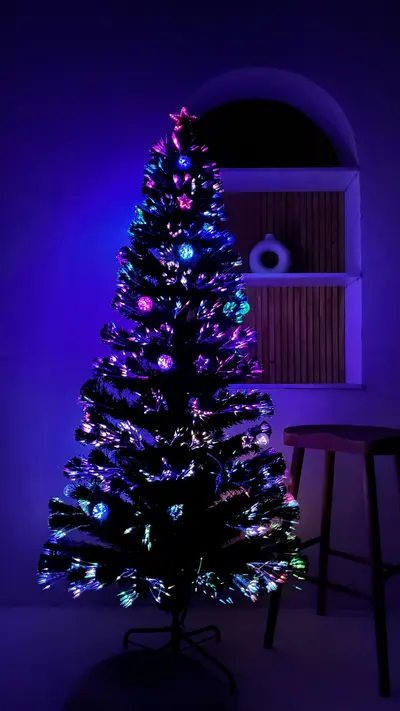 Árbol de fibra óptica con estrellas iluminado de noche